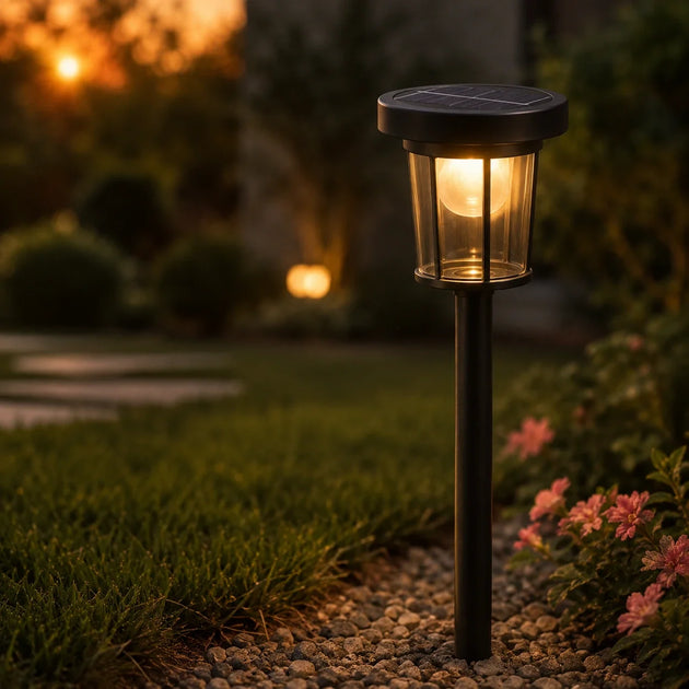 Solar garden light glowing at dusk in a gravel garden bed — solar lights Ireland